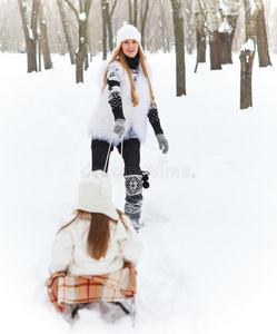 小女孩和妈妈在雪橇上玩得很开心