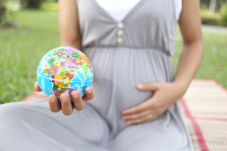 孕妇在手显示全球模型