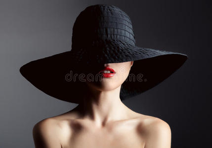 戴帽子的漂亮女人。 复古时尚。 黑暗的背景。