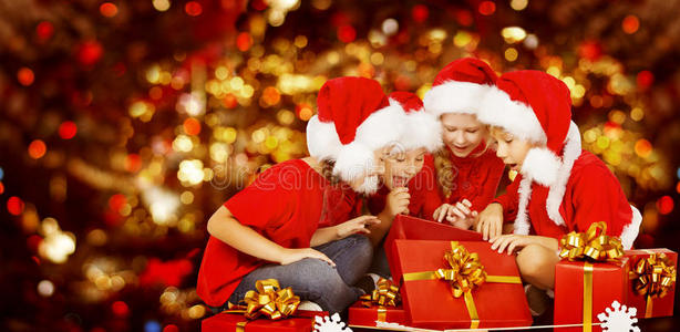 圣诞孩子打开礼物盒，孩子们戴着圣诞帽