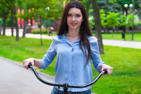 在城市公园里骑着老式自行车的美女