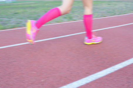 模糊背景 女跑步运动员腿运行轨道 体育和健身的概念