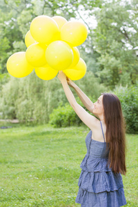 幸福的年轻女人，用黄色的气球