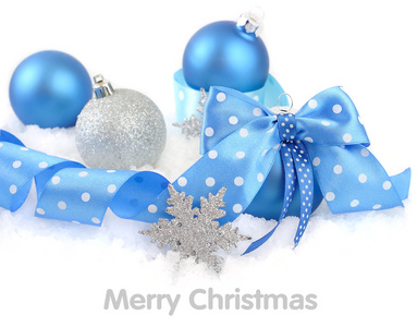 圣诞球着雪白色背景上一个蓝色蝴蝶结。圣诞节背景以及放置文本的位置