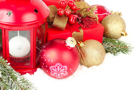 圣诞节组成的金黄色和红色的圣诞球和冰雪覆盖树枝的白色背景上的一棵圣诞树上的礼品盒。圣诞节背景以及放置文本的位置