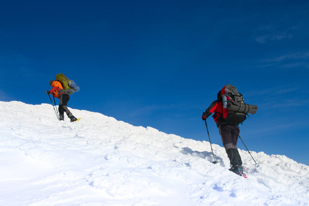 在山里徒步旅行带着背包和帐篷雪的冬天