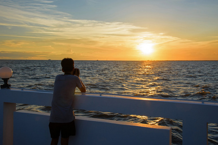 摄影师拍摄海上日落照片