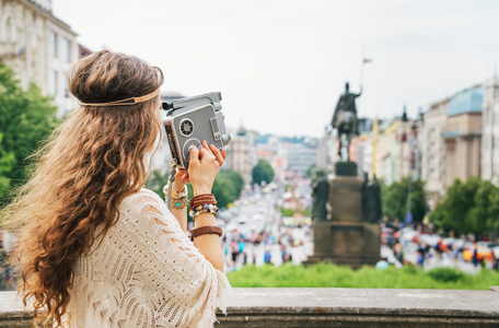 时尚嬉皮女游客与复古相机在布拉格