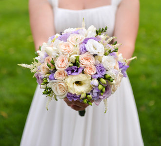 新娘紧握着五颜六色的鲜花的婚礼花束