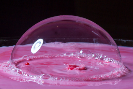 乳汁飞溅在粉红色下的泡