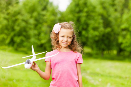 小女孩拿着飞机玩具