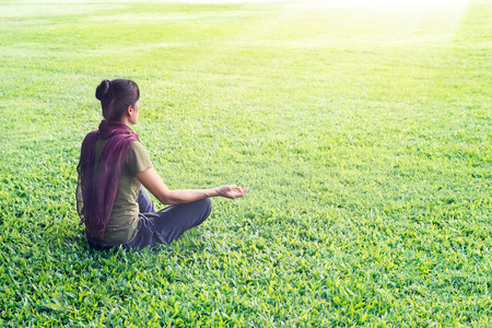 在公园草地场背景上冥想户外瑜伽女人
