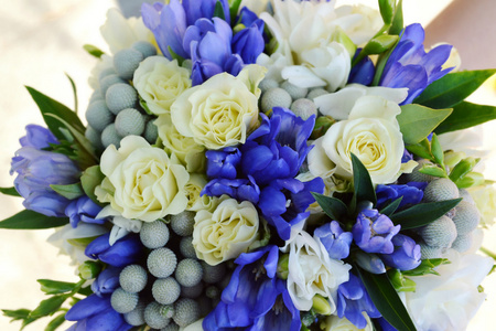 美丽的新娘抱着杏和蓝色玫瑰婚礼花束