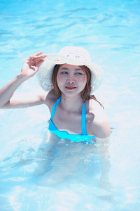 亚洲美丽的年轻女子头戴帽穿比基尼在海滩上