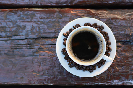 黑咖啡的咖啡豆的旧木桌上的杯子