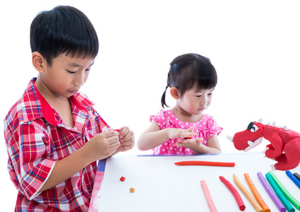 亚洲小孩玩玩黏土在桌子上。加强意