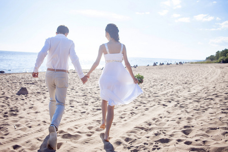 只是结婚幸福的夫妇，在一片沙滩上运行