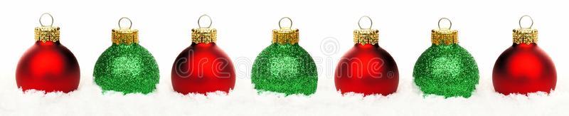 红色和绿色圣诞饰品在地里隔离开来