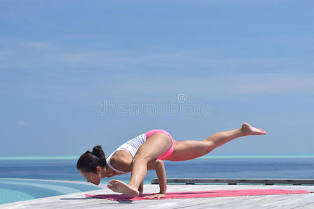 在海边练习瑜伽的亚洲华人妇女