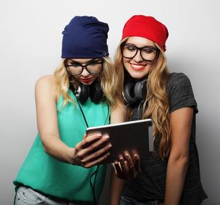 两个时髦女孩朋友使用数字平板电脑