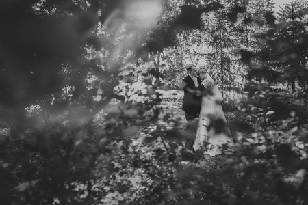 黑白照片美丽年轻夫妇站在背景森林