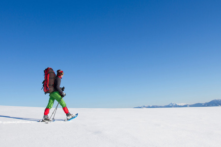 在山里徒步旅行带着背包和帐篷雪的冬天