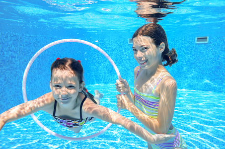 孩子们在水下，快乐积极的女孩已经在水里，孩子们运动家庭度假的乐趣的游泳池里游泳