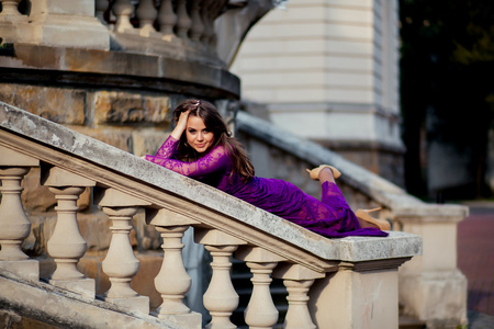 年轻女子躺在栏杆附近的一座古城堡。可好看