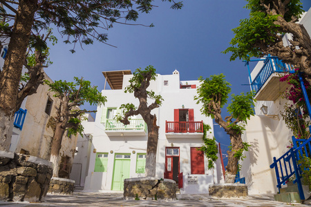 在湛蓝的天空和树木，希腊麦克诺斯岛小镇的小广场