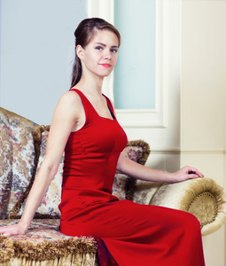 在豪华的内饰件红色的连衣裙的女人