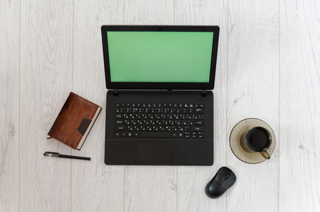 笔记本电脑 大杯咖啡和一个笔记本上的一张小木桌背景。顶视图