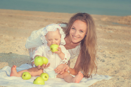快乐漂亮的妈妈和女儿享受海滩时间
