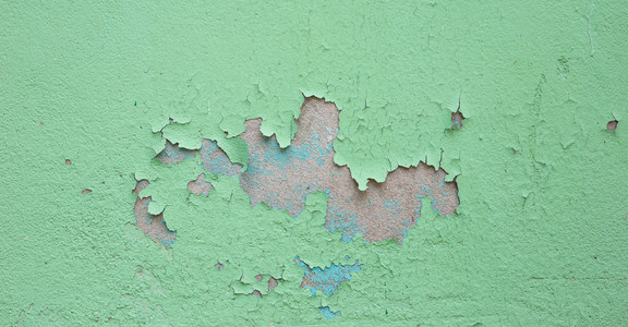 在旧绿色墙上剥落油漆