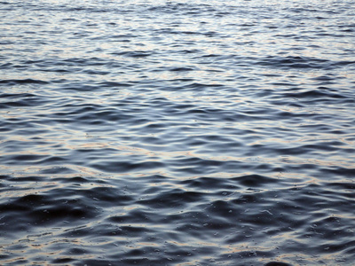 深蓝色的海水波纹和反映日落