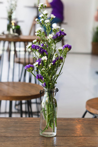 木制的桌子上有一个玻璃花瓶里的花