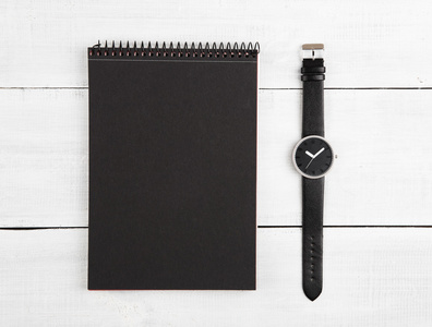 记事本和木桌上的手表
