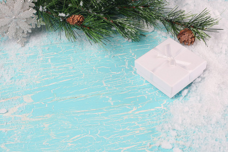 礼品盒 雪和云杉枝在木板上画