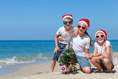 三个快乐的孩子们在沙滩上打了一天时间