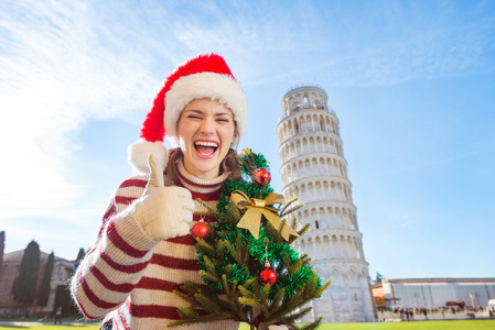 圣诞节树显示近靠旅游竖起大拇指的女人