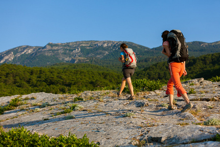 两名妇女在克里米亚山脉背着背包徒步旅行