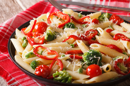 与上一盘蔬菜特写的意大利面食。水平