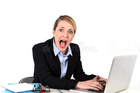 女商人坐在办公桌旁，紧张地拿着笔记本电脑，看起来很沮丧