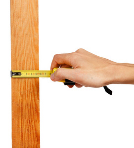 用测量胶带在木板上的男性手的特写