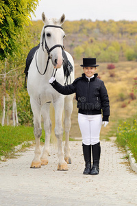 年轻女孩和白色盛装舞步马