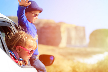 快乐的小男孩和女孩乘汽车在山