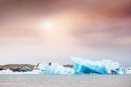 在日落时 Jokulsarlon 冰川湖蓝色冰山