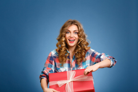 年轻的女孩，在一个红色的圣诞礼品包装一个盒子