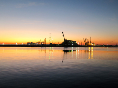 起重机和在日落时港口码头的形状