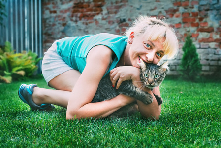 女孩和一只猫在草地上玩