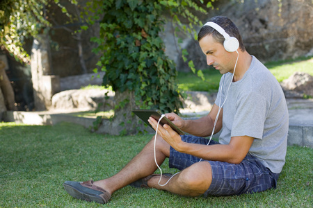 年轻人与戴着耳机的 tablet pc 听音乐放松